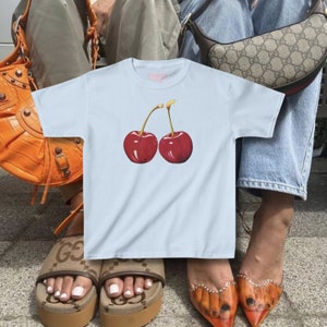 model wears awomens baby tee shirt displaying a y2k cherry