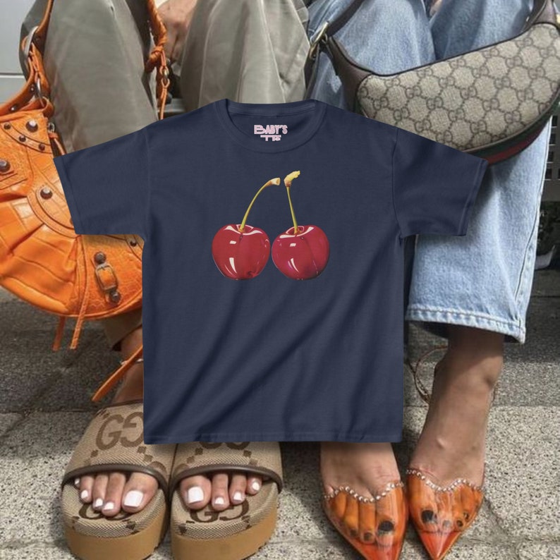 model wears awomens baby tee shirt displaying a y2k cherry
