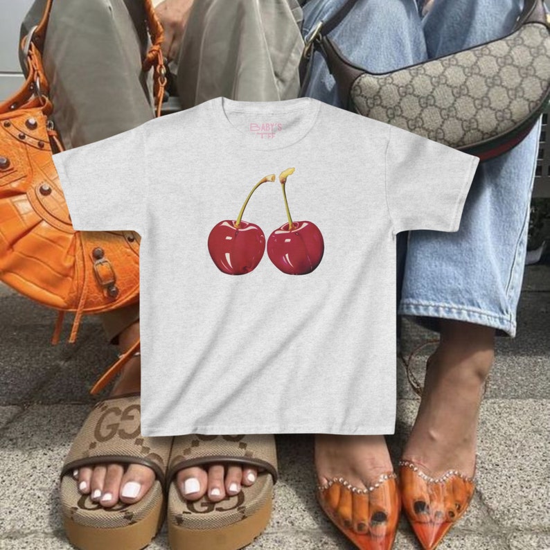 model wears awomens baby tee shirt displaying a y2k cherry