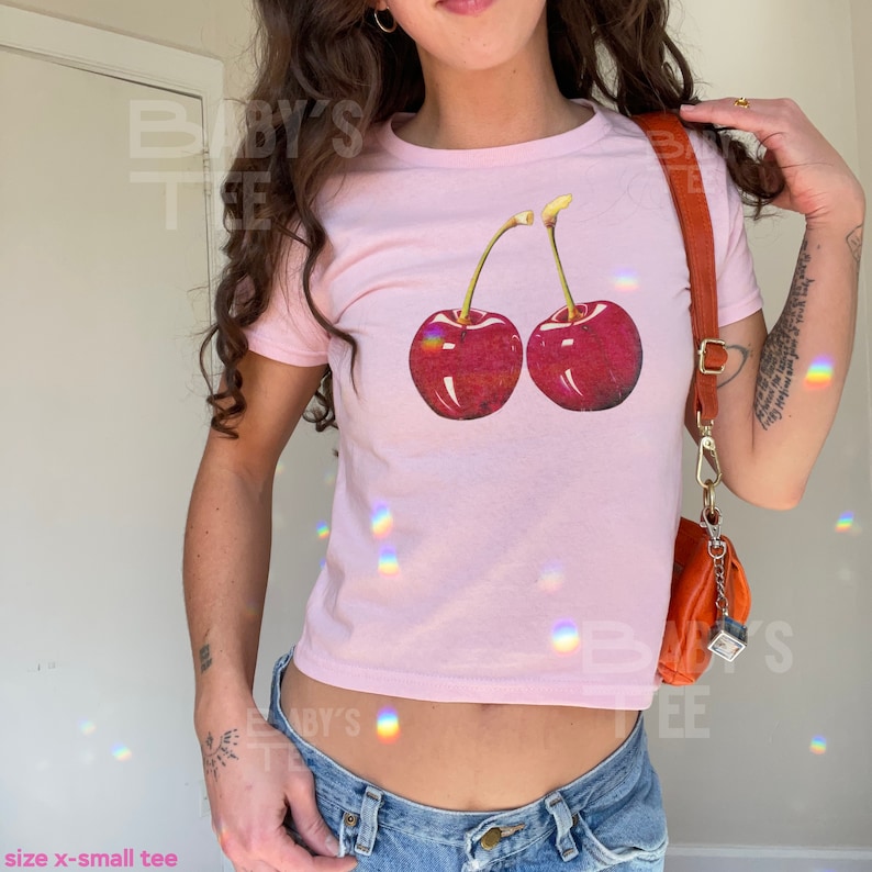 model wears awomens baby tee shirt displaying a y2k cherry