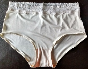 May include: Cream-colored high-waisted underwear with a delicate lace trim at the waistband. The underwear has a smooth, seamless design and a comfortable fit. The fabric appears to be soft and stretchy, suitable for everyday wear.
