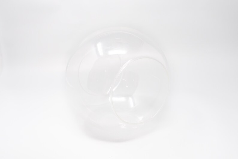 K&ouml;nnte beinhalten: Ein rundes Terrarium aus klarem Glas mit einer kleineren &Ouml;ffnung an der Seite. Das Terrarium ist perfekt f&uuml;r die Pr&auml;sentation kleiner Pflanzen oder anderer dekorativer Gegenst&auml;nde.