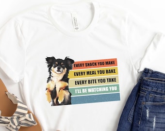May include: White t-shirt with a graphic of a chihuahua dog and the text "EVERY SNACK YOU MAKE, EVERY MEAL YOU BAKE, EVERY BITE YOU TAKE, I'LL BE WATCHING YOU".