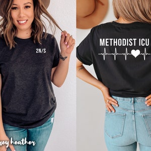 May include: A black and dark grey heather t-shirt with the text "METHODIST ICU" and a heart beat graphic on the back. The front of the shirt has the text "2N/S" on the left chest.