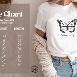 Pu&ograve; includere: Tabella delle taglie per una t-shirt unisex a maniche corte bianca con una grafica di farfalla nera e il testo "kindness counts". La tabella mostra le taglie XS a 4XL con le misure di petto e lunghezza corrispondenti in pollici.