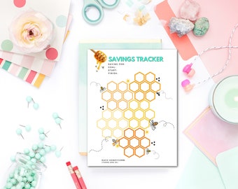May include: A printable savings tracker with a honeycomb design. The tracker is decorated with bees and honey. The text on the tracker reads "Savings Tracker" and "Saving for: Goal, Start, Finish". Each honeycomb represents a savings goal. There are 51 honeycombs on the tracker.