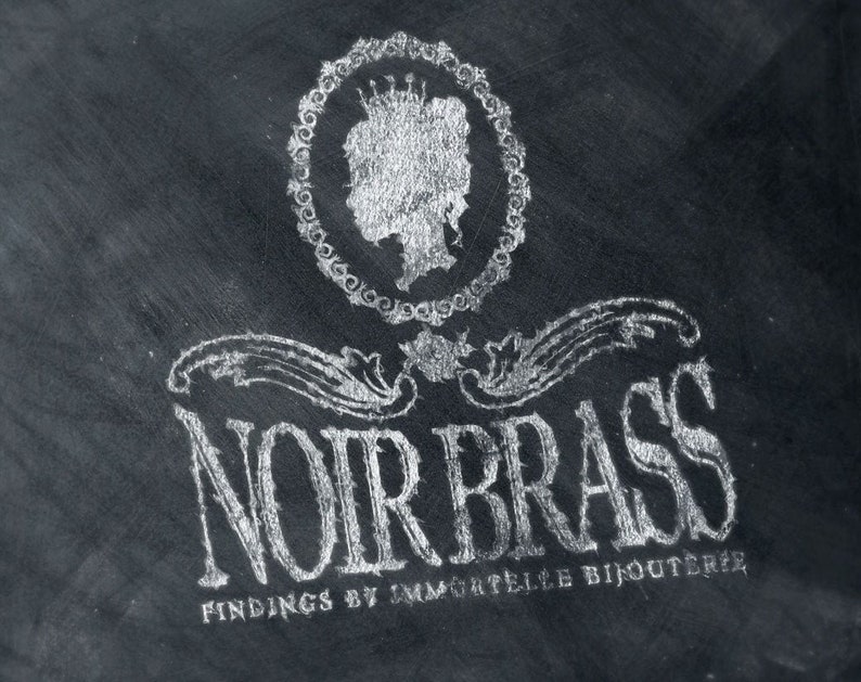 Puede incluir: Una imagen en blanco y negro de un logotipo para una joyer&iacute;a llamada "Noir Brass Findings by Immortelle Bijouterie". El logotipo presenta una imagen estilizada de la cabeza de una mujer con una corona, rodeada de un c&iacute;rculo de elementos decorativos.