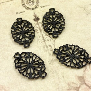 Puede incluir: Cuatro abalorios de filigrana de metal negro en forma ovalada con un dise&ntilde;o floral.