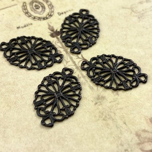 Puede incluir: Cuatro abalorios de filigrana de metal negro en forma ovalada con un dise&ntilde;o decorativo. Los abalorios tienen un acabado desgastado.