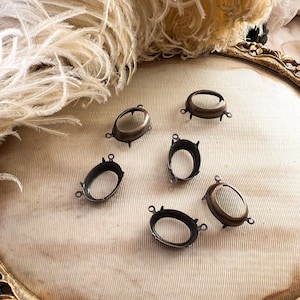 以下が含まれることがあります： 装飾的なデザインが施された、楕円形の金属製の設定が6つ。設定は薄い茶色の表面上にある。