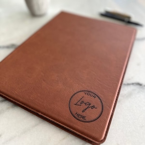 May include: A brown leather portfolio with a circle logo that says "Your Logo Here" in black.