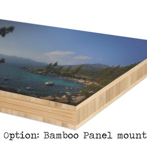 May include: A close-up of a bamboo panel mount with a printed image of a lake and mountains. The image is printed on a smooth surface and the bamboo panel is made of multiple layers of wood.
