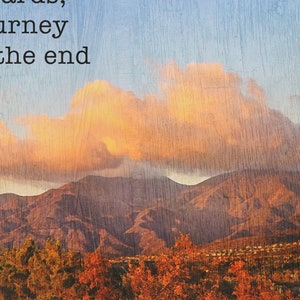 May include: A photograph of a mountain range with a large, fluffy cloud in the sky. The mountains are brown and the sky is blue. The text "There an end towards; journey to the end" is at the top of the image. The text "detail view" is at the bottom of the image.