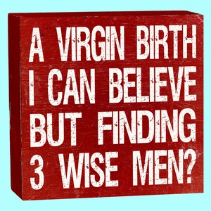 May include: Red wooden sign with white text that reads "A virgin birth I can believe but finding 3 wise men?"