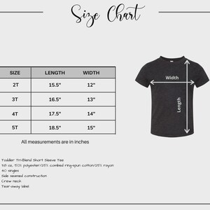 May include: A size chart for a toddler tri-blend short sleeve tee. The chart shows sizes 2T to 5T with length and width measurements in inches. The tee is dark gray and has a crew neck. The chart also lists the fabric composition and construction details.