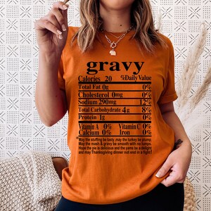 May include: Orange t-shirt with the word "gravy" at the top, followed by a nutrition facts label. The label lists calories, fat, cholesterol, sodium, carbohydrates, and protein. A Thanksgiving-themed poem is printed at the bottom.