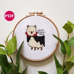 May include: Cross-stitch embroidery of a llama in a wooden hoop. The llama is white and black with a red collar and the text "count dracu-llama". A pink circle with "PDF" is in the upper left corner. The embroidery is surrounded by green leaves.