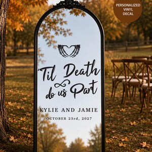 May include: An arched floor mirror with a black frame featuring a black vinyl decal. The decal displays a skeleton hand heart graphic, the text 'Til Death do us Part', the names 'KYLIE AND JAMIE', and the date 'OCTOBER 23rd, 2027' in black lettering.