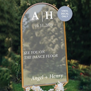 May include: A gold-framed arch mirror with a white vinyl decal that says "A|H 10.11.2025 See you on the dance floor Angel + Henry" and a blue circle with the text "Vinyl Decal Only".