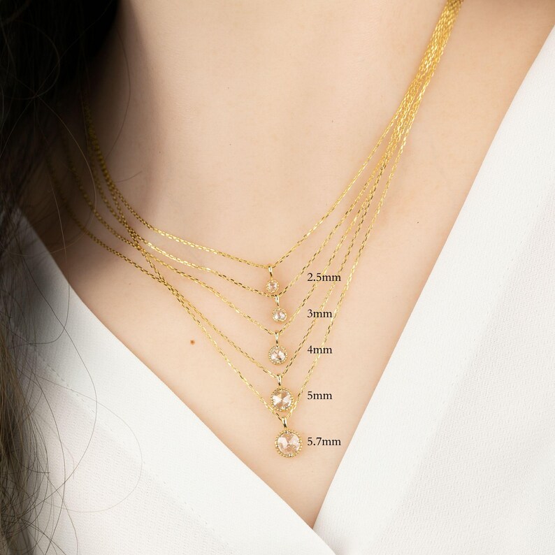 May include: Five gold necklaces with different sized clear gemstone pendants. The pendants are 2.5mm, 3mm, 4mm, 5mm, and 5.7mm in diameter.