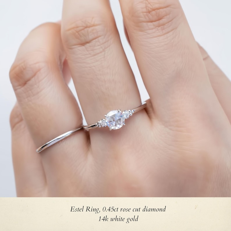 May include: A delicate silver ring with a rose cut diamond and smaller accent diamonds. The ring is set in 14k white gold. Estel Ring, 0.45ct rose cut diamond 14k white gold