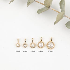 May include: Five gold pendants with clear round stones of different sizes. The pendants are 2.5mm, 3.0mm, 4.0mm, 5.0mm, and 5.7mm in diameter.