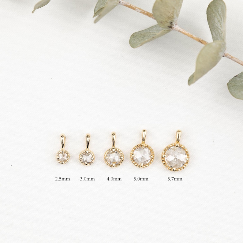 May include: Five gold pendants with clear round stones of different sizes. The pendants are 2.5mm, 3.0mm, 4.0mm, 5.0mm, and 5.7mm in diameter.