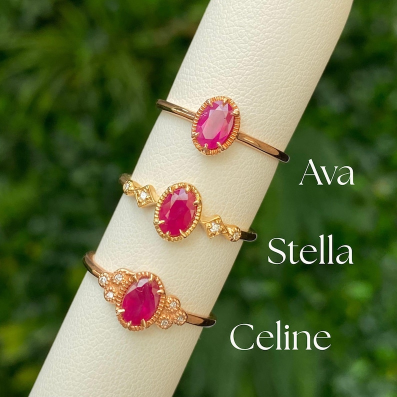 May include: Three gold rings with red oval gemstones and small diamonds. The rings are labeled "Ava", "Stella", and "Celine".