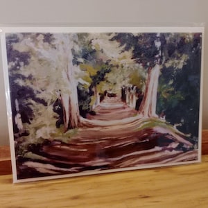 May include: A rectangular art print featuring an impressionistic painting of a dirt path winding through a forest. The scene displays tall trees with light-colored trunks on either side, casting shadows across the brown path under a canopy of green.