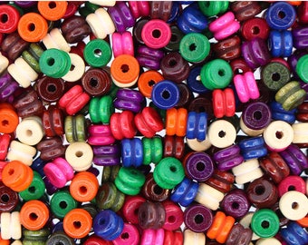 May include: A collection of colorful wooden beads with a variety of colors, including red, blue, green, purple, and brown. The beads are all round and have a hole in the center. They are perfect for crafting and jewelry making.