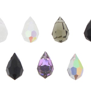 May include: Assortment of teardrop-shaped crystal beads in various colors, including clear, iridescent, black, and gray.