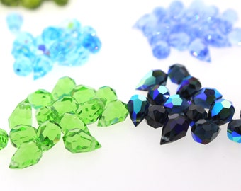 May include: Assortment of faceted glass teardrop beads in green, blue and iridescent blue.