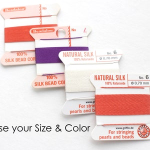 May include: Four spools of beading thread in different colors: red, purple, white, and orange. The spools are labeled "Beadalon" and "Natural Silk". The thread is 0.70 mm thick and is for stringing pearls and beads.
