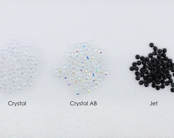 May include: Three piles of rhinestones, one clear, one iridescent, and one black. The piles are labeled "Crystal", "Crystal AB", and "Jet".