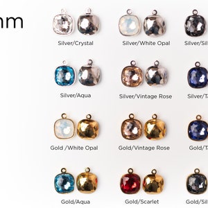 May include: Assortment of 10mm square glass charms with different colors and finishes. The charms are attached to silver and gold metal loops. The colors include crystal, white opal, silver night, aqua, vintage rose, tanzanite, scarlet.