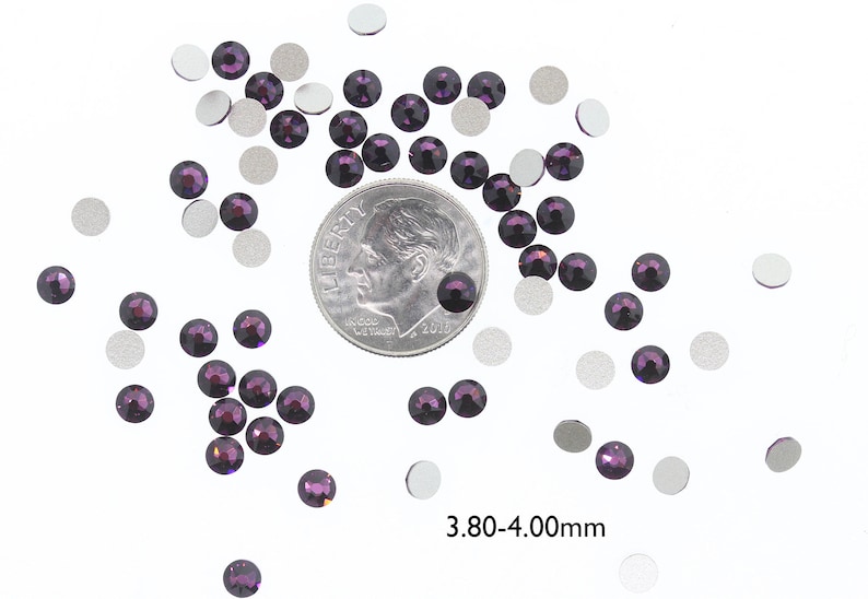 May include: A scattering of small, dark purple rhinestones, some with silver backing, next to a US dime for size comparison. The rhinestones are approximately 3.80-4.00 mm in size.
