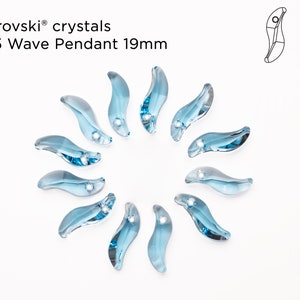 May include: A close-up of ten light blue crystal wave pendant charms, each measuring 19mm. The charms are arranged in a circle on a white background. The text "Swarovski crystals 6525 Wave Pendant 19mm" is visible at the top of the image.