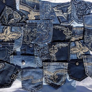 Puede incluir: Una colecci&oacute;n de bolsillos de jeans de mezclilla con varios dise&ntilde;os bordados. Los bolsillos son en tonos de azul y presentan patrones intrincados con pedrer&iacute;a y lentejuelas.