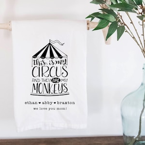 May include: A white kitchen towel with a black and white illustration of a circus tent and the text "This is my circus and they are my monkeys". The text "Ethan Abby Braxton we love you mom!" is also printed on the towel.