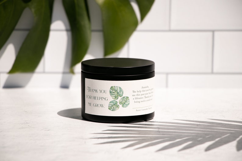 May include: Black candle jar with a white label that reads "Thank you for helping me grow." The label also features a green and white illustration of a monstera leaf.