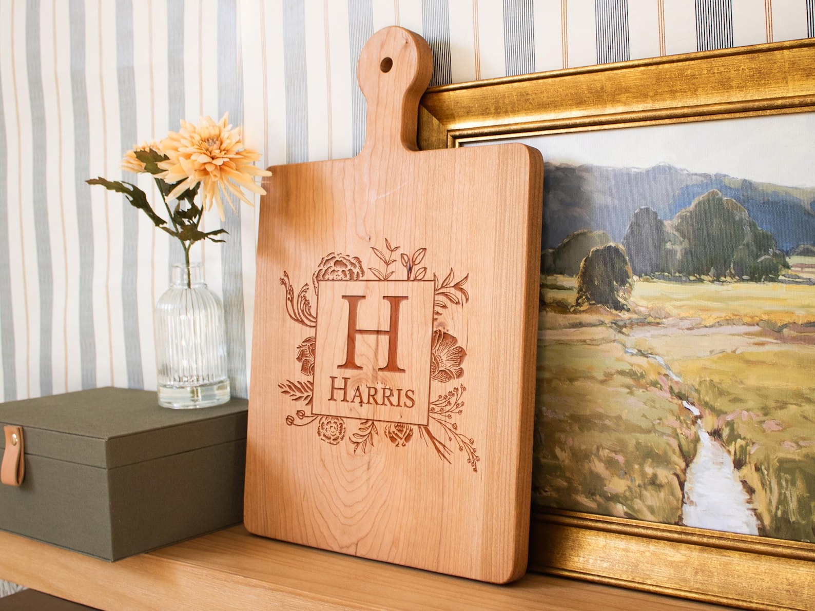 A wooden cutting board with a floral design and customized text