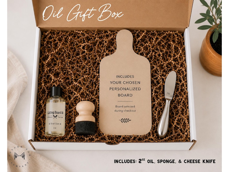 a gift box containing various items, including a cutting board, a bottle of oil, a sponge, and a cheese knife. The box is open, revealing the contents inside.