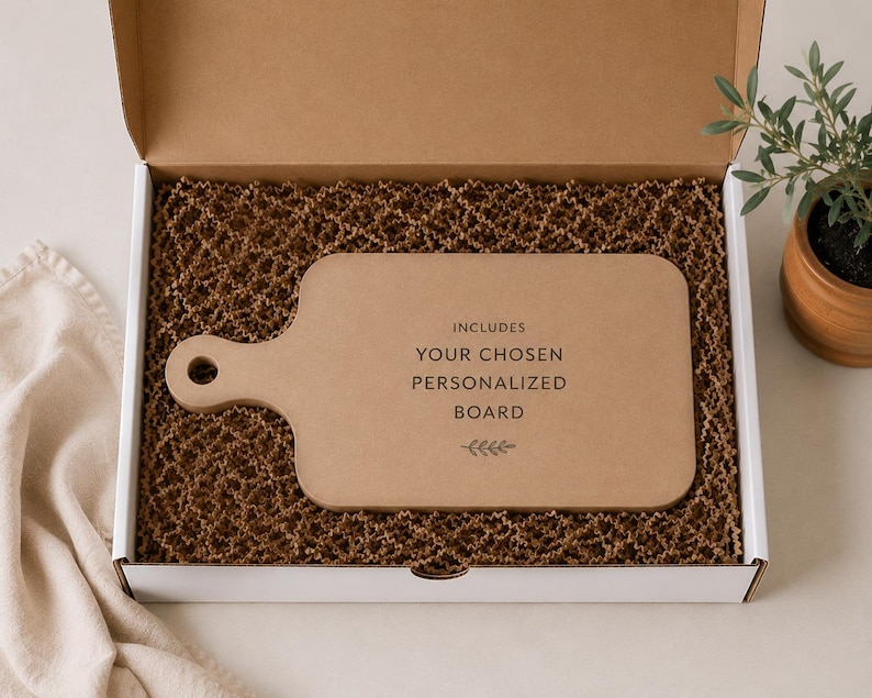 a cardboard box containing a wooden cutting board, with a potted plant and a cloth visible in the background.