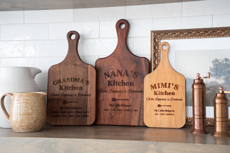 Three brown wooden cutting boards on a kitchen counter