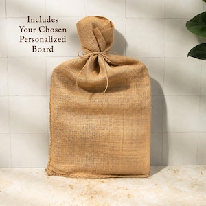 A burlap sack tied with a string, placed on a white tiled surface against a white wall.