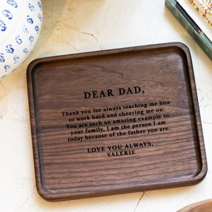 May include: A wooden tray with a personalized message engraved on the surface. The message reads "Dear Dad, Thank you for always teaching me how to work hard and cheering me on. You are such an amazing example to your family, I am the person I am today because of the father you are. Love you always, Valerie."