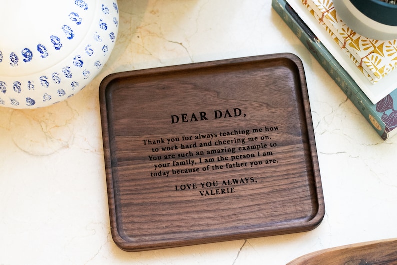 May include: A wooden tray with a personalized message engraved on the surface. The message reads "Dear Dad, Thank you for always teaching me how to work hard and cheering me on. You are such an amazing example to your family, I am the person I am today because of the father you are. Love you always, Valerie."