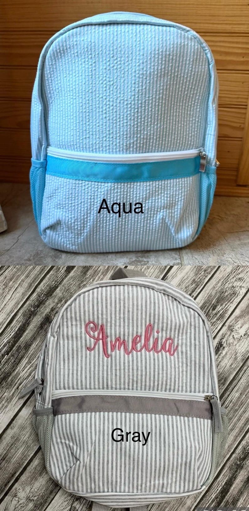 May include: Two seersucker backpacks. One is light blue with the word "Aqua" and a white zipper. The other is gray and white striped with the name "Amelia" in pink and the word "Gray".