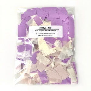 May include: A clear plastic bag filled with purple and white confetti. The bag has a label that reads "POMVILLAGE Party Supplies and Decorations Instagram/Pinterest: PomVillage www.PomVillage.Etsy.com"