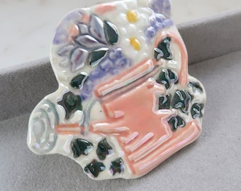 Broche vintage con forma de regadera y flores